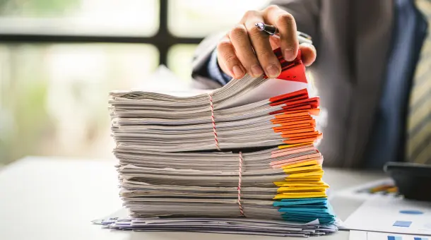 Hand durchsucht Dokumentenstapel