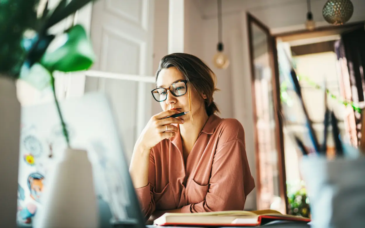 Frau sitzt nachdenklich vorm Laptop