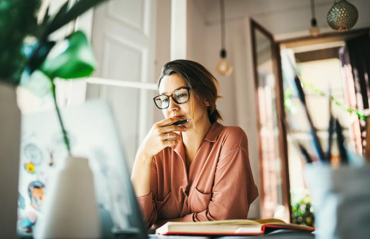 Frau sitzt nachdenklich vorm Laptop