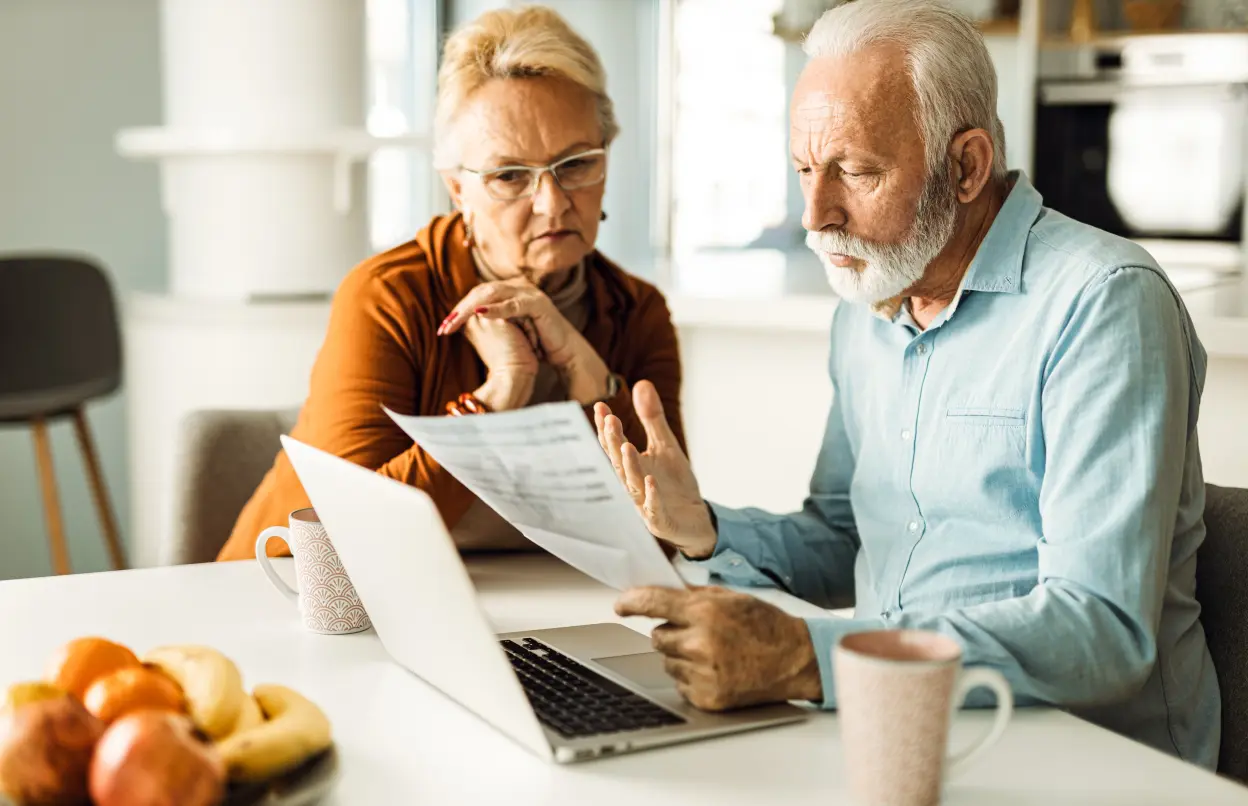 Älteres Paar schaut gemeinsam auf Dokument