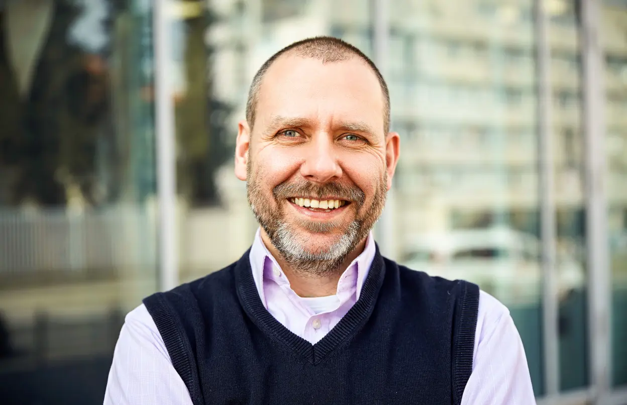 Mann lächelt entspannt in die Kamera