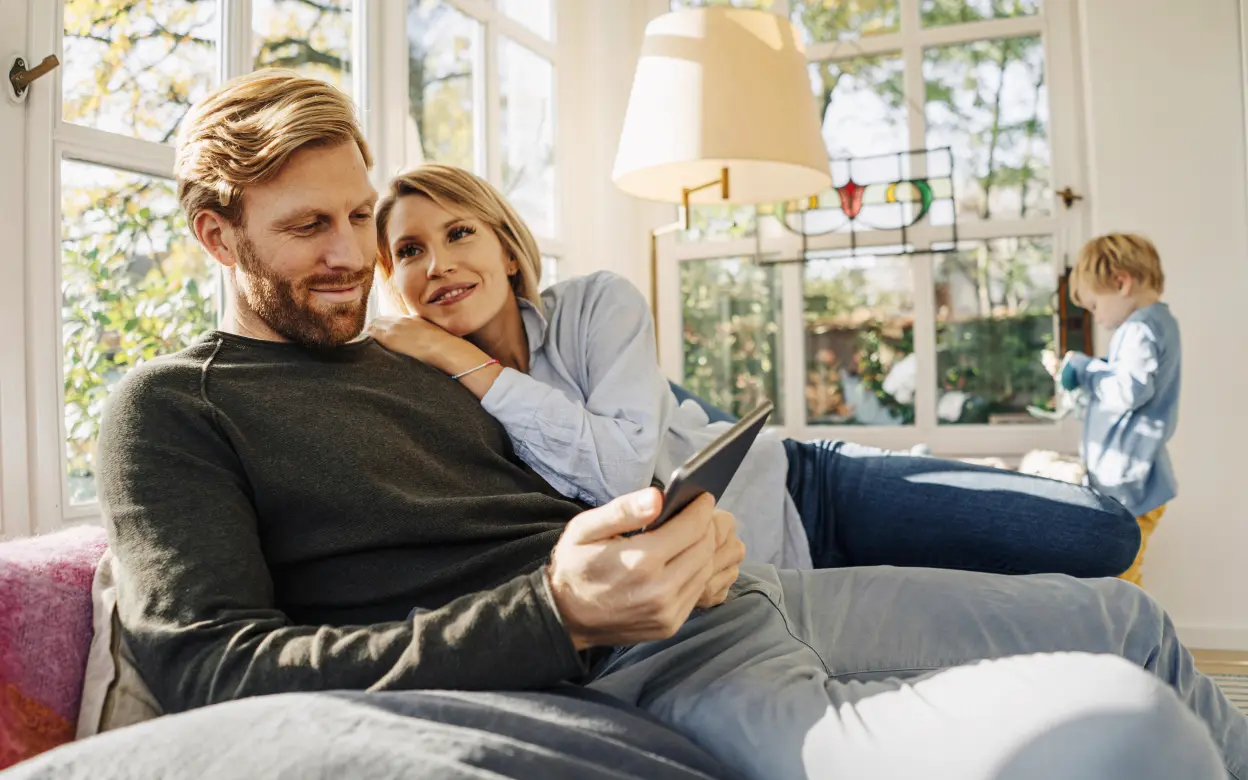 Paar sitzt mit Tablet auf dem Sofa