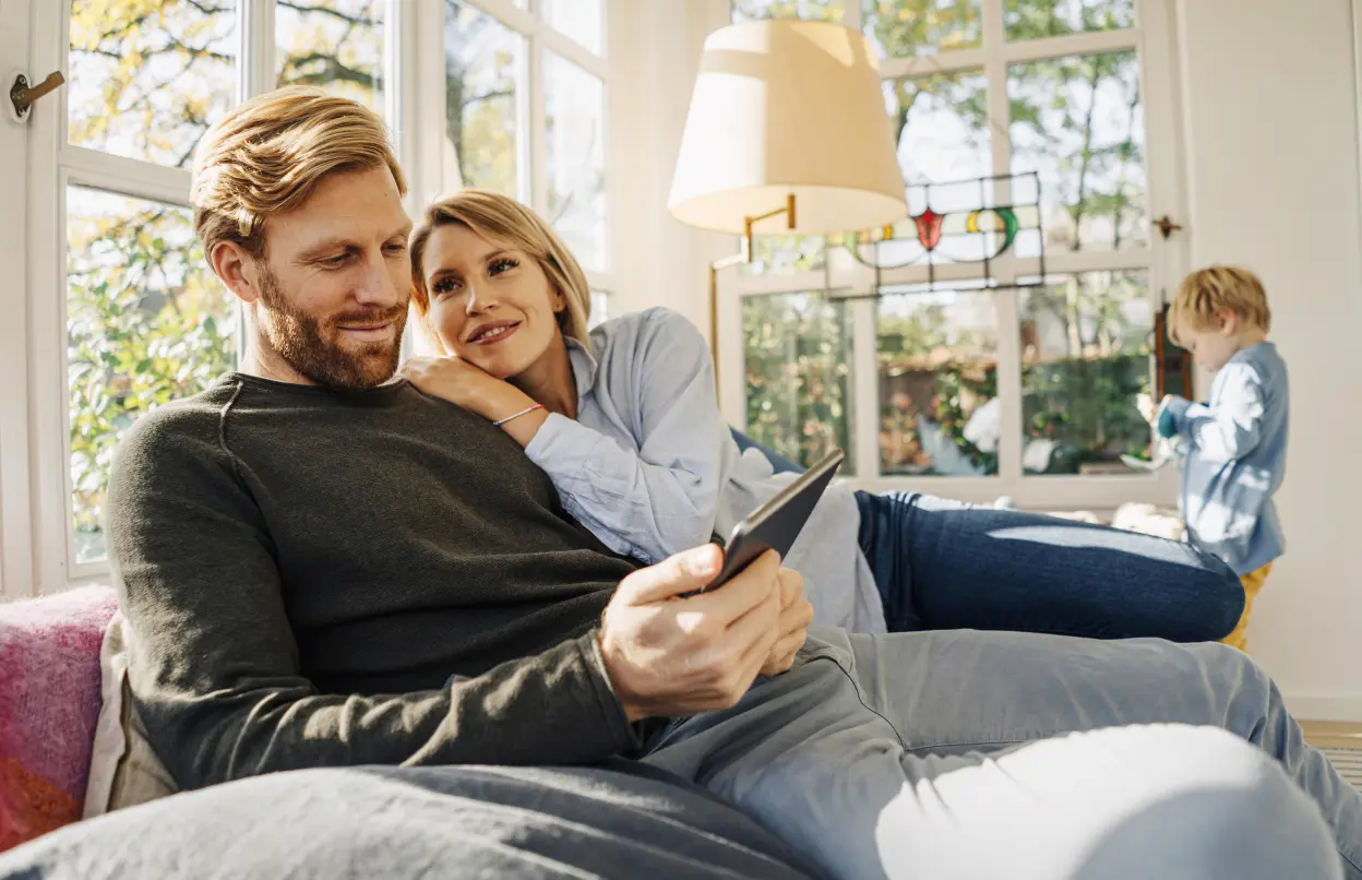 Paar sitzt mit Tablet auf dem Sofa
