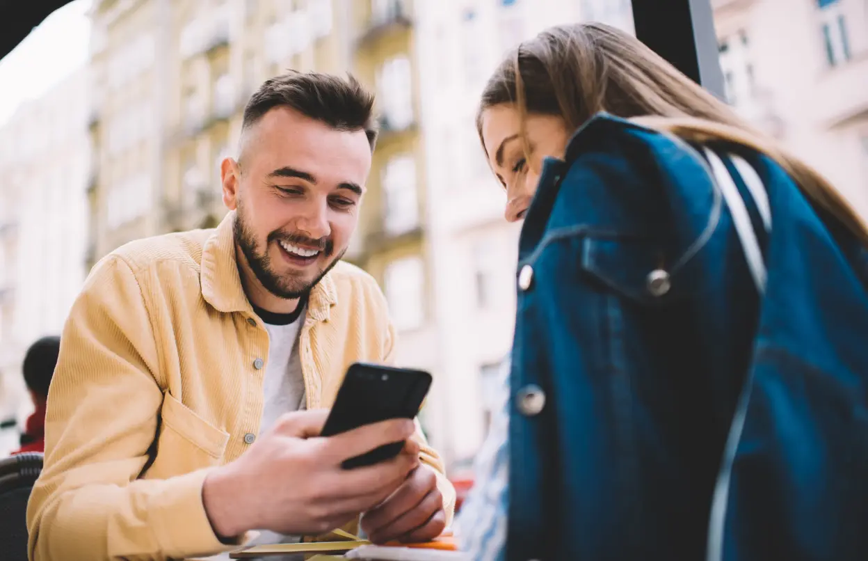 Junges Paar schaut gemeinsam aufs Handy