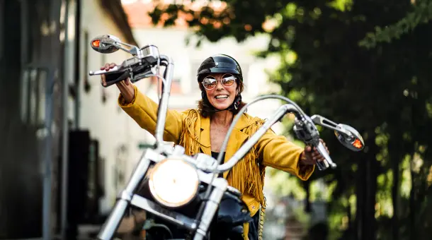Lächelnde Frau sitzt auf Motorrad