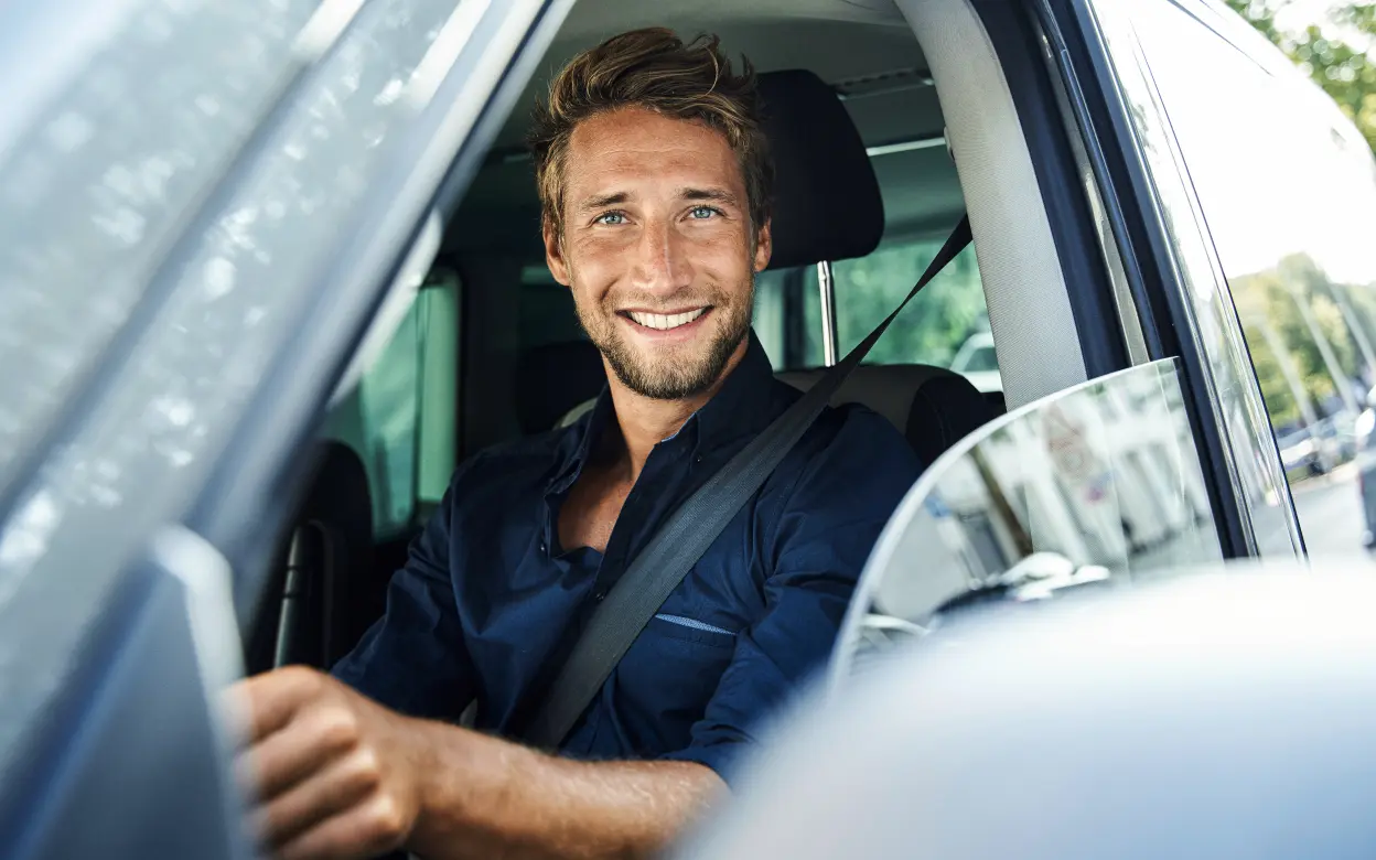 Freundlich lächelnder Mann im Auto