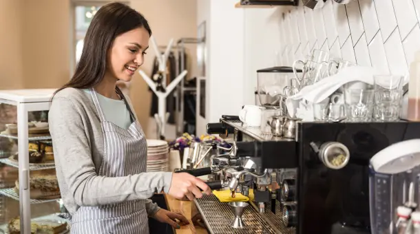 Frau bedient Kaffeemaschine