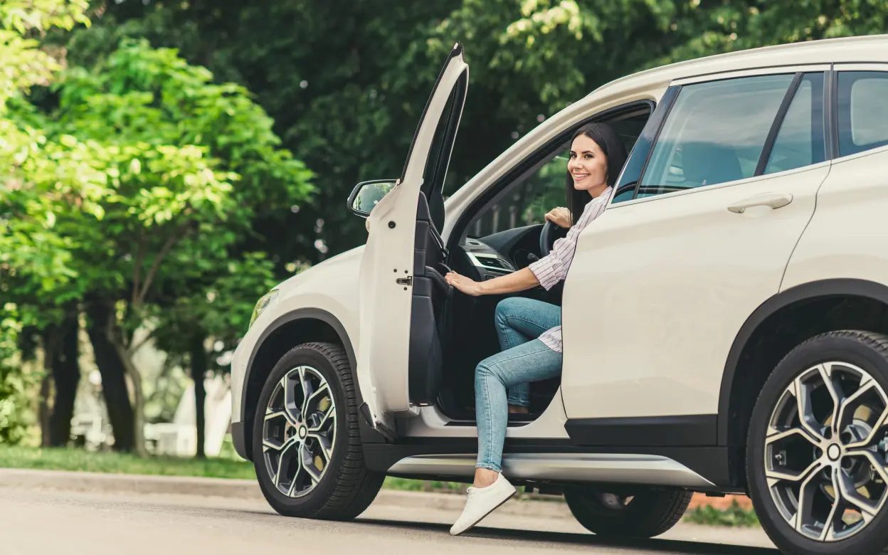 Frau steigt aus Auto aus | © deagreez/stock.adobe.com Frau steigt aus Auto aus