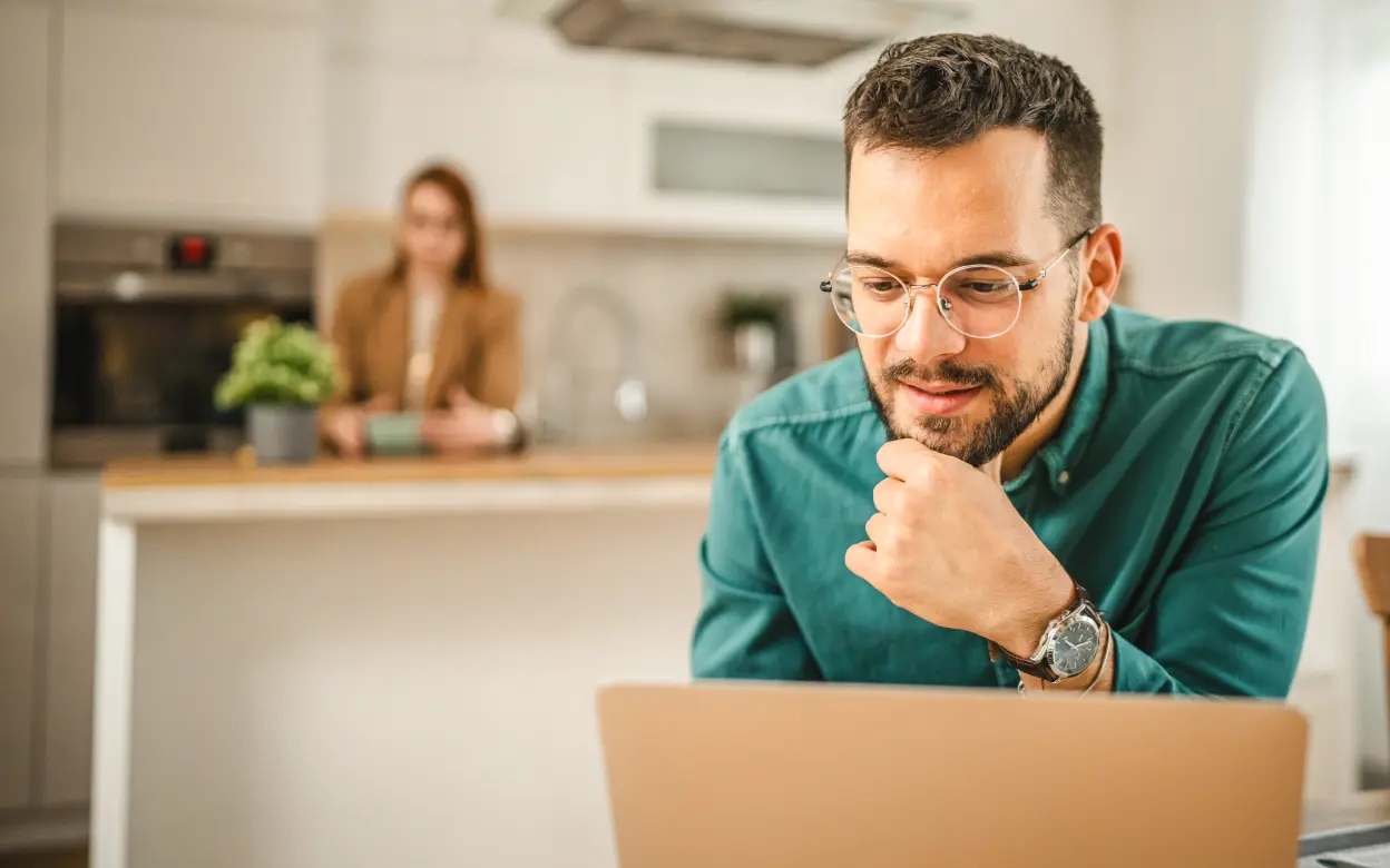 Mann sitzt konzentriert vor Laptop