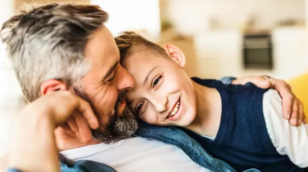 Vater und Sohn sitzen innig auf der Couch