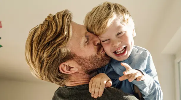 Vater küsst seinen lachenden Sohn