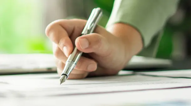 Eine Person hält einen Füller in der Hand.